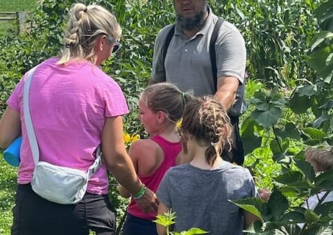 An Amish farmer giving a mother and her children a tour of Old Windmill Farm in Ronks, PA